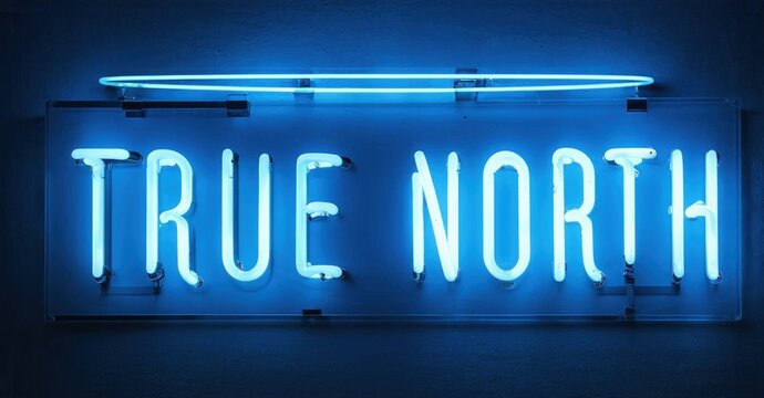 Bright neon sign displays True North. Blue glow illuminates dark background. Simple rectangular design creates striking visual impact.