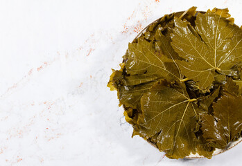 canned grape leaves, for cooking dolma, on a plate,