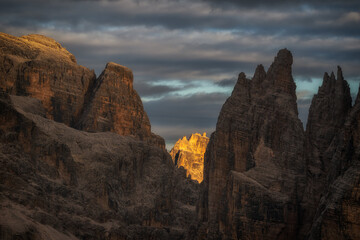 High-resolution shot of rugged mountain spires at sunset. Sharp textures and dramatic lighting highlight the geological details of the alpine landscape.