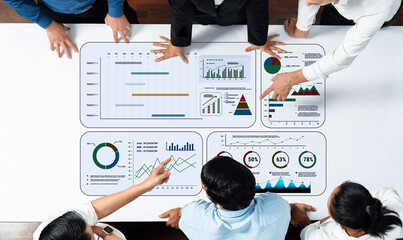 A professional business team collaborates in a modern office, analyzing data and discussing...