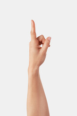 Fototapeta premium Human hand pointing vertically upwards, making a gesture of selection, indicating direction, or interacting with a virtual screen or interface on a plain background