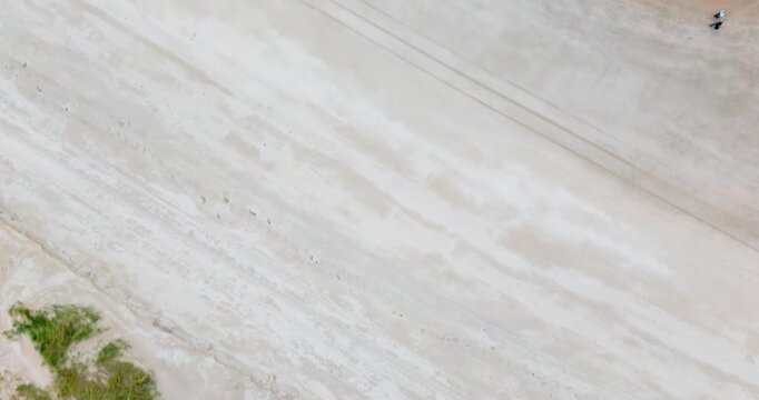 humans walking at a beach in birdview