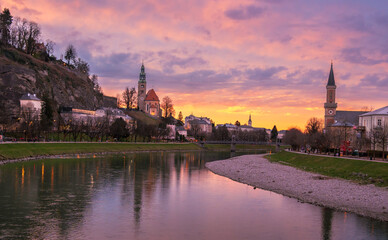 Naklejka premium Evening view of Salzac River, Salzburg Old town, church in Austria during sunset.