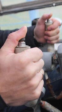 Vertical video. Close-up. Male young hands of a married pilot take the vintage airplane steering wheel. Vintage style. Old historical cockpit of the Soviet An-2.