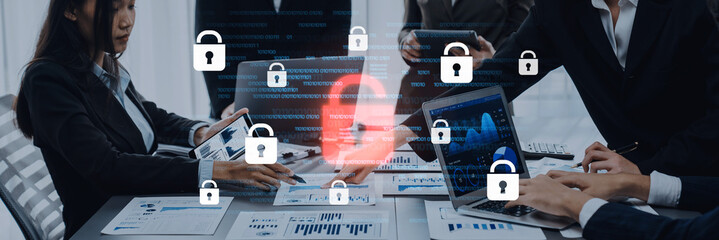 A business meeting focused on data security featuring professionals using laptops and digital lock icons, symbolizing cyber protection and teamwork in an office setting. Trope