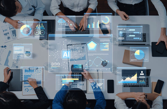 Team collaborates on AI technology in a modern workspace, using digital tools and data visualization to enhance business strategies and foster innovation. Trope - Powered by Adobe