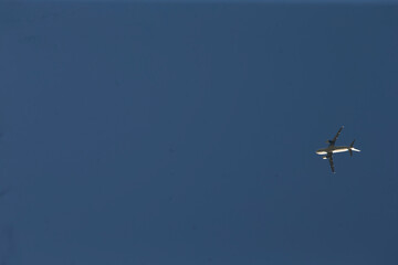 Single jet cruising across azure sky, clear midair shot showing aircraft silhouette and subtle contrail, dynamic travel scene conveying motion, distance and modern aviation freedom