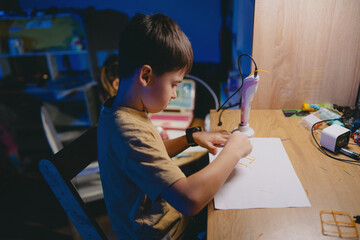 Quiet young boy working diligently with pencil under lamp light
