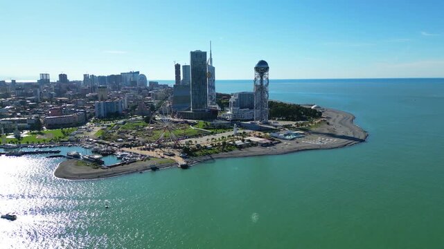 Bird's-eye view of Batumi landmarks in clear winter. 4K horizontal drone footage captures the city's architecture, iconic buildings, and streets under sunny skies during a warm snowless winter.