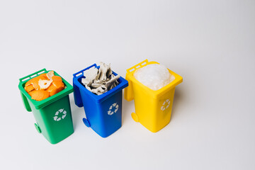Three color-coded recycle bins filled with organic waste, paper, and plastic, promoting environmental awareness and sustainable waste management practices