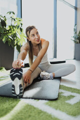Athletic blonde girl performing flexibility training and cooling down after a workout