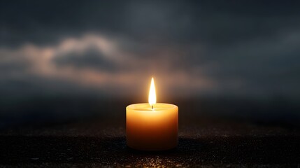 A single lit candle glows in the deep darkness casting a warm solitary light against a moody cloudy background