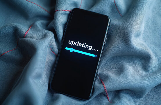 Smartphone screen shows updating process with progress bar. Mobile phone software installing new version. Device needs update, loading information. - Powered by Adobe