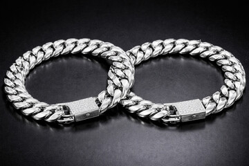 Two cuban silver bracelets with a black background