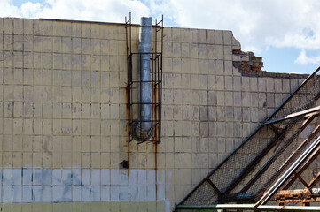 Old Industrial building with tiles and metal chimney. Facade of abandoned factory building