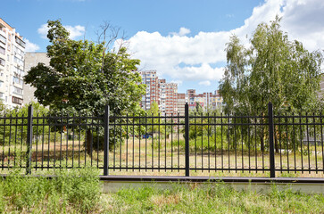 Metal fence in the city park. Decorative black iron guardrail for protection, close up