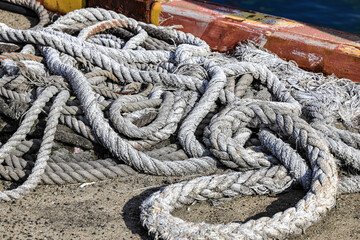 Fototapeta premium Mooring line on rusty pier bollard referred to a post on a ship or quay.