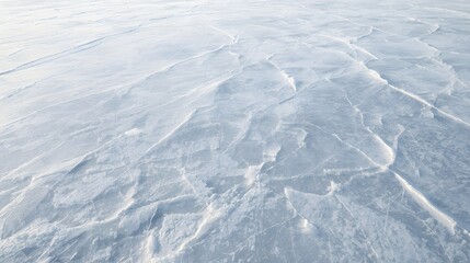 Fototapeta premium Aerial view of snow-covered landscape with textured surface and patterned terrain