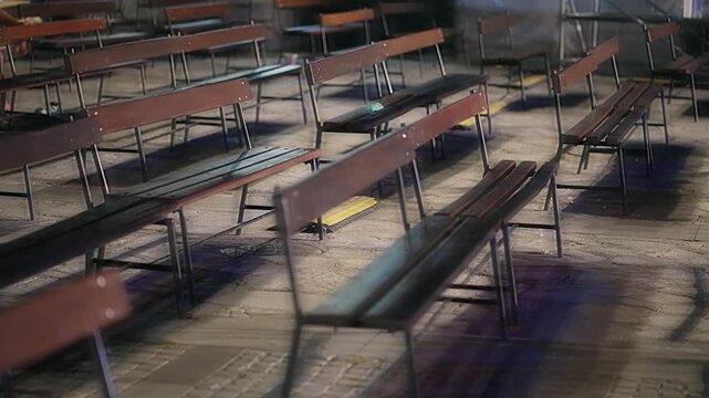 Outdoor theater auditorium. Benches stacked in rows. adjacent. There is an alley between the wooden benches