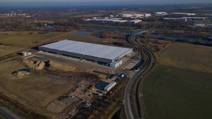 New logistics center building with construction area. Majestic aerial view drone - Powered by Adobe