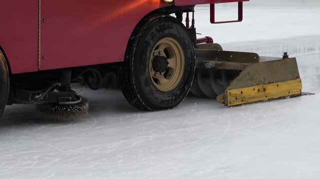 Ice resurfacing machine operates on rink during hockey game in winter