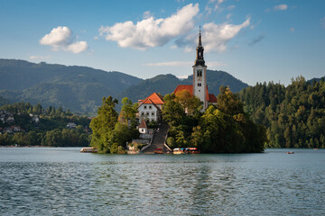 The stunning Pilgrimage Church of Mary the Queen rests on a small island in Lake Bled, Slovenia, surrounded by turquoise water and lush mountains.