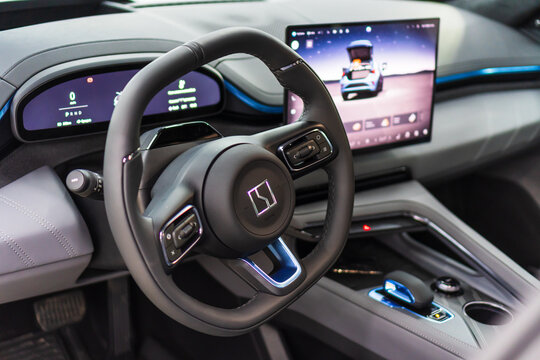 Zeekr 001 EV leather interior - dashboard, steering wheel with logo and buttons. Zeekr logo on steering wheel. Zeekr is a Chinese electric car brand by Geely. 