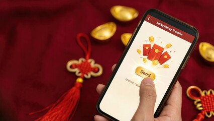 Finger Pressing Send Button with Golden Coins and Red Ang Bao for Lucky Money Transfer on Chinese New Year