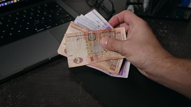 Businessmen leave Ukraine money bills on hand, which is called Hryvnia. Paper banknotes of various denominations