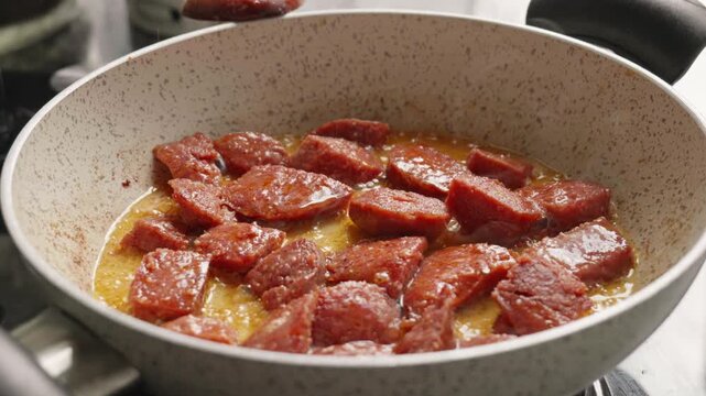 Traditional Turkish Sausage (Sucuk) Frying in a Pan With Oil Splashes in Slow Motion