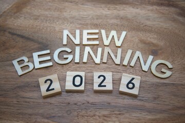 New beginning 2026 message created from wooden letters on wood material background with copy space...