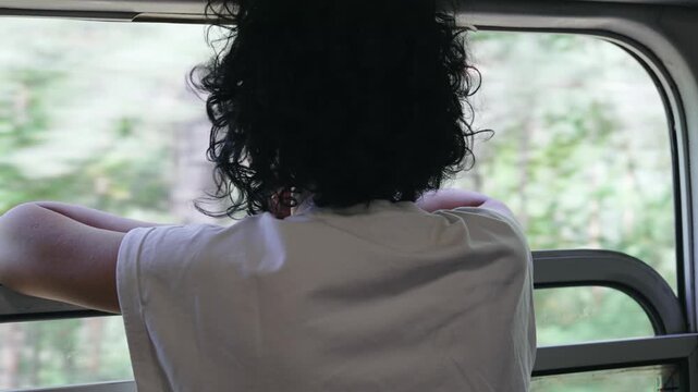 A young traveler woman rides vintage train transport and looks out the window, slow motion