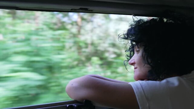 Business woman looking out of a train window during her daily commute. Traveling on vintage train in mountain forest, slow motion