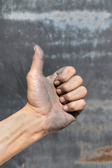 Industrial worker hand showing thumbs up agreement gesture after completed work