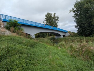 Rzeka z porośniętymi zielenią brzegami i most © rychu.pl