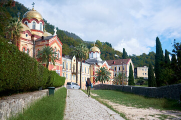 Girl walks toward temple, blending human spiritual journey with architectural grandeur and cultural tradition.