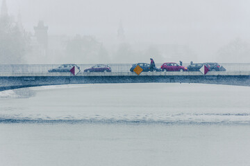 Zima w mieście; Wrocław - przechodnie i samochody na moście Pokoju nad zamarzniętą rzeką Odrą