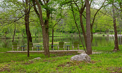 Green lawn chairs facing water