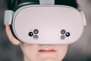 Young person wearing virtual reality headset, engaged in immersive experience, showcasing modern technology and digital interaction in a contemporary environment