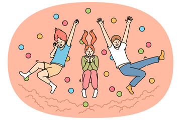 Children jump in pool with balls, laughing and enjoying opportunity to frolic with friends from primary school. Pool with balls in amusement park with little boys and girls diving from great height