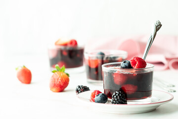 Close up of freshly made mixed berry gelatin dessert cups, ready for eating.