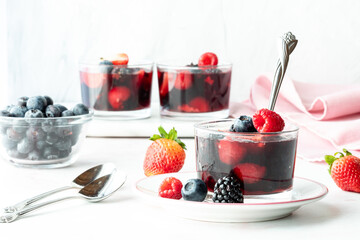 Mixed berry jelly cups against a light background, ready for eating.