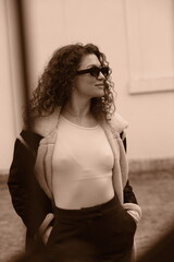 Obraz premium Woman in winter coat and sunglasses. Sepia portrait. Smile and emotional