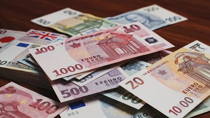 A diverse collection of international paper currency including Euros Turkish Lira Japanese Yen and US Dollars meticulously spread across a rich wooden surface symbolizing global finance economic exch. - Powered by Adobe