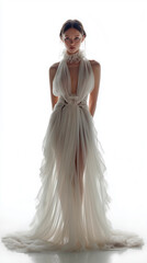 Full length portrait of a young woman in an elegant flowing white dress isolated on white background.