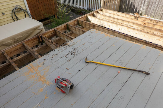 Wooden deck foundation with boards removed and old nails sticking up