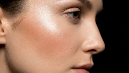 Close-up of a young womans face with natural makeup and glowing skin.