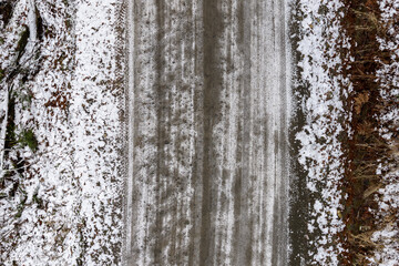 Obraz premium Aerial View Of Snowy Road Cutting Through Forest With Snow And Ice