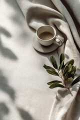 Handmade ceramic cup resting on natural linen fabric with soft daylight and gentle shadows, embodying an eco-minimal lifestyle concept