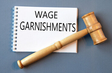 WAGE GARNISHMENTS - words in a white notebook on a gray background with a judge's gavel